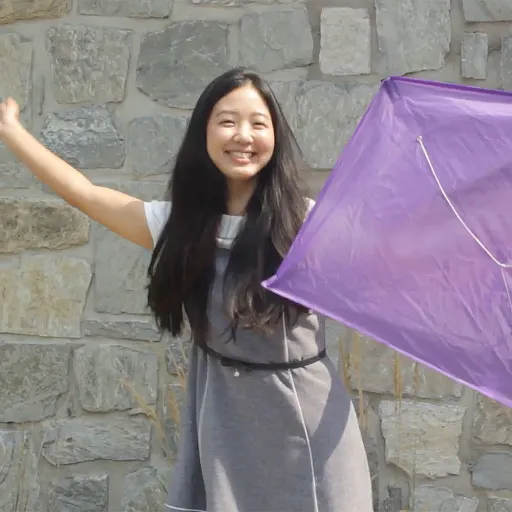 young ministry lady with hands outstretched holding purple InFaith kite