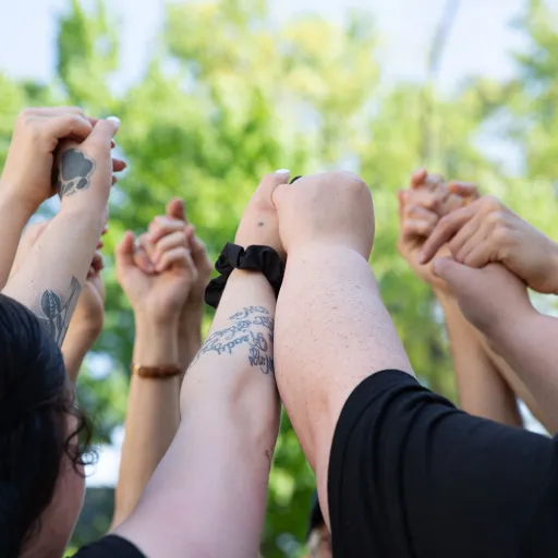 hands held high together in teamwork circle