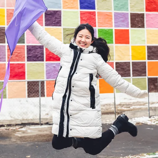 Mira kim with kite in front of colorful background wall