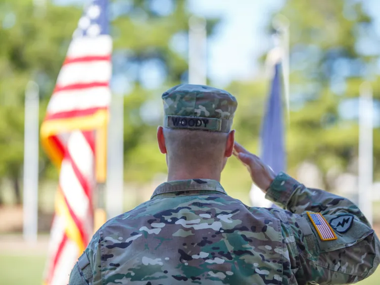 army chaplain soluting the American flag