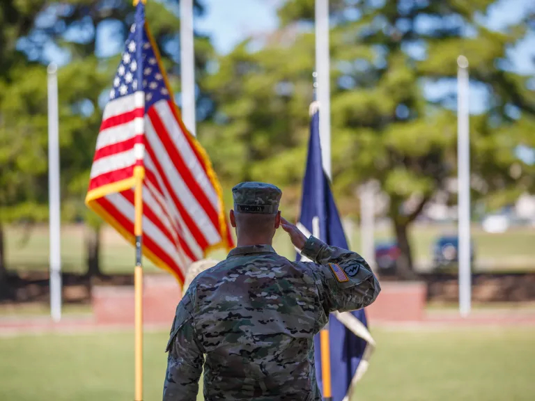 chaplain in front of flags