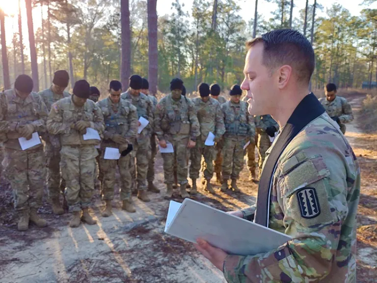 chaplain praying over soldiers