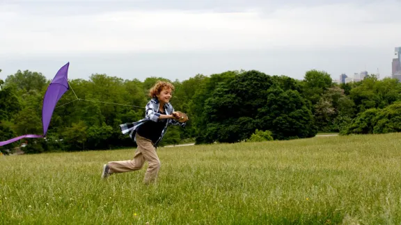 boy flying purple InFaith kite