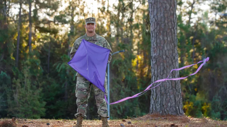 army chaplain holding a purple InFaith kite