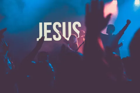 praise and worship performance with illuminated JESUS sign